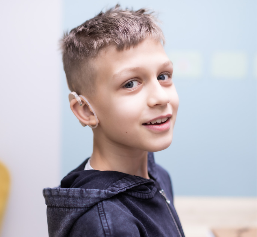zdjęcie przedstawiające chłopca z aparatem słuchowym
